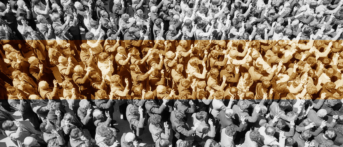 black and white photo from above of a crowd of people in Appenzel raising their hands to vote
